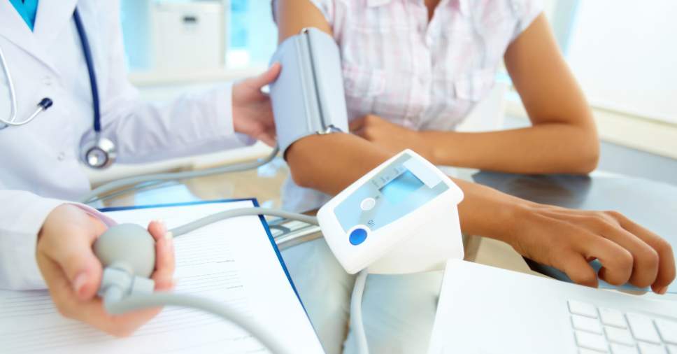 Médico mede pressão, mostrando que a medicina do trabalho é essencial para a saúde laboral.