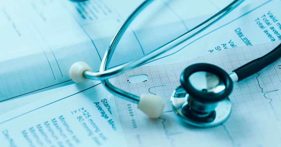 Estetoscópio sobre um gráfico médico: o processo de retorno ao trabalho após afastamento por doença.