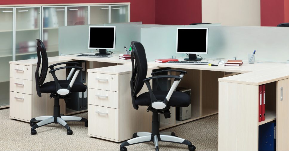 Estações de trabalho vazias em escritório moderno ilustram o impacto do absenteísmo na empresa.